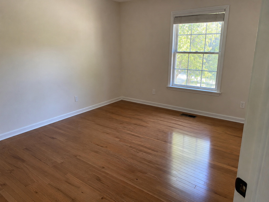 Clean hardwood floors in an empty room after professional cleaning